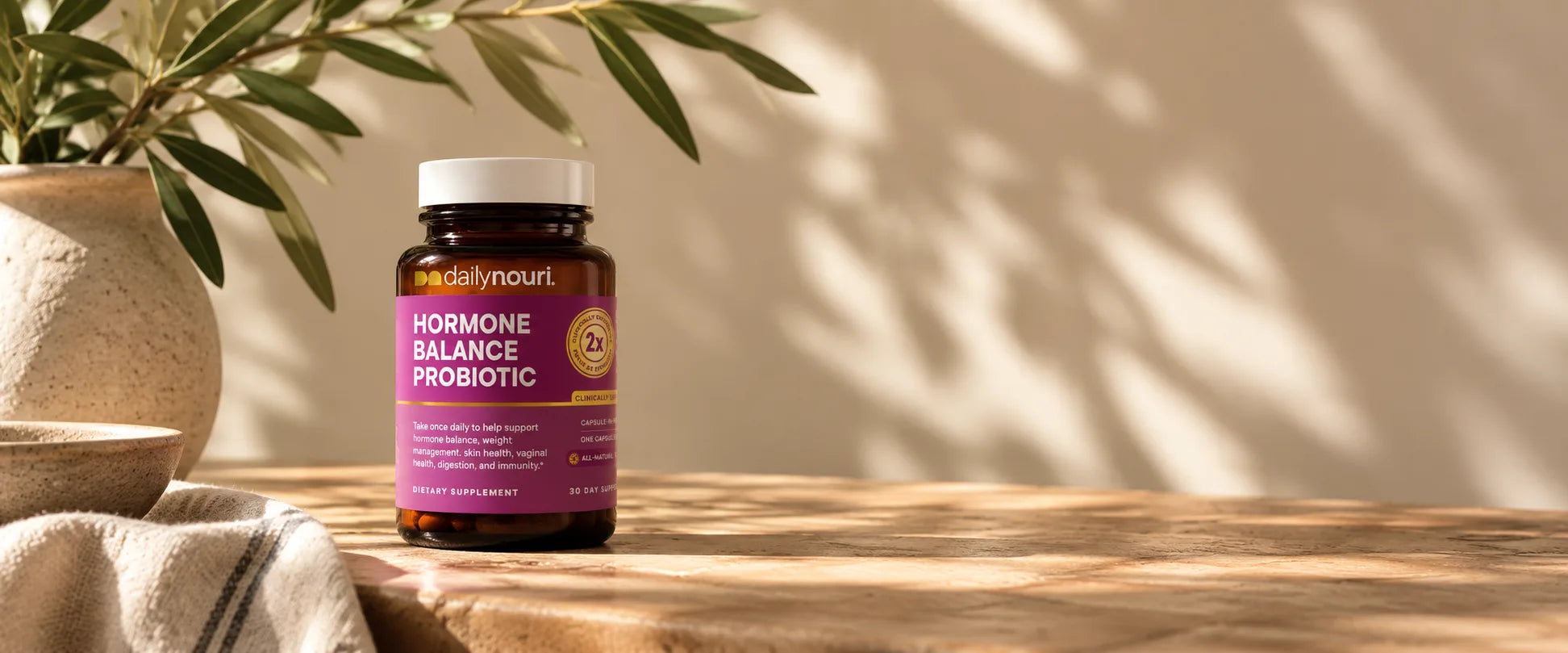 Hormone Balance Probiotic on a sunlit stone counter beside an olive branch